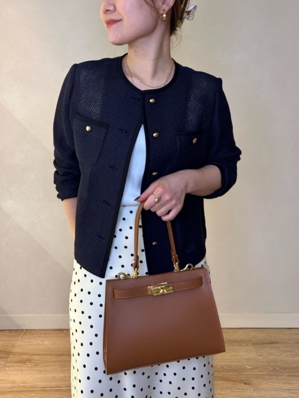 ホワイト系のスカート、イエロー系のショルダーバッグ、ブルー系のノーカラージャケットを着用したレディースの春コーディネートの6枚目の写真