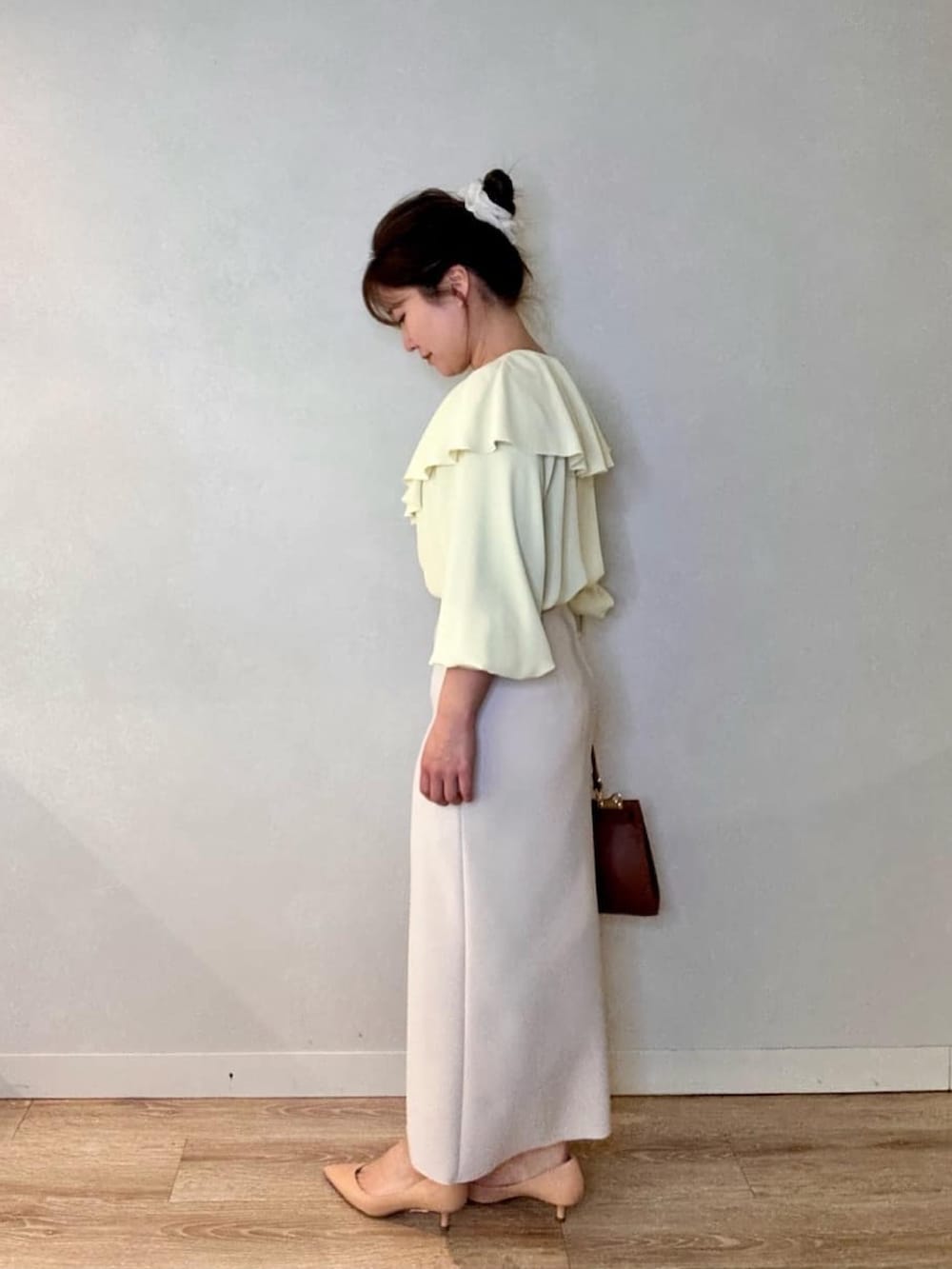 ブラック系のスカート、イエロー系のシャツ/ブラウス、イエロー系のショルダーバッグを着用したレディースの春コーディネートの3枚目の写真