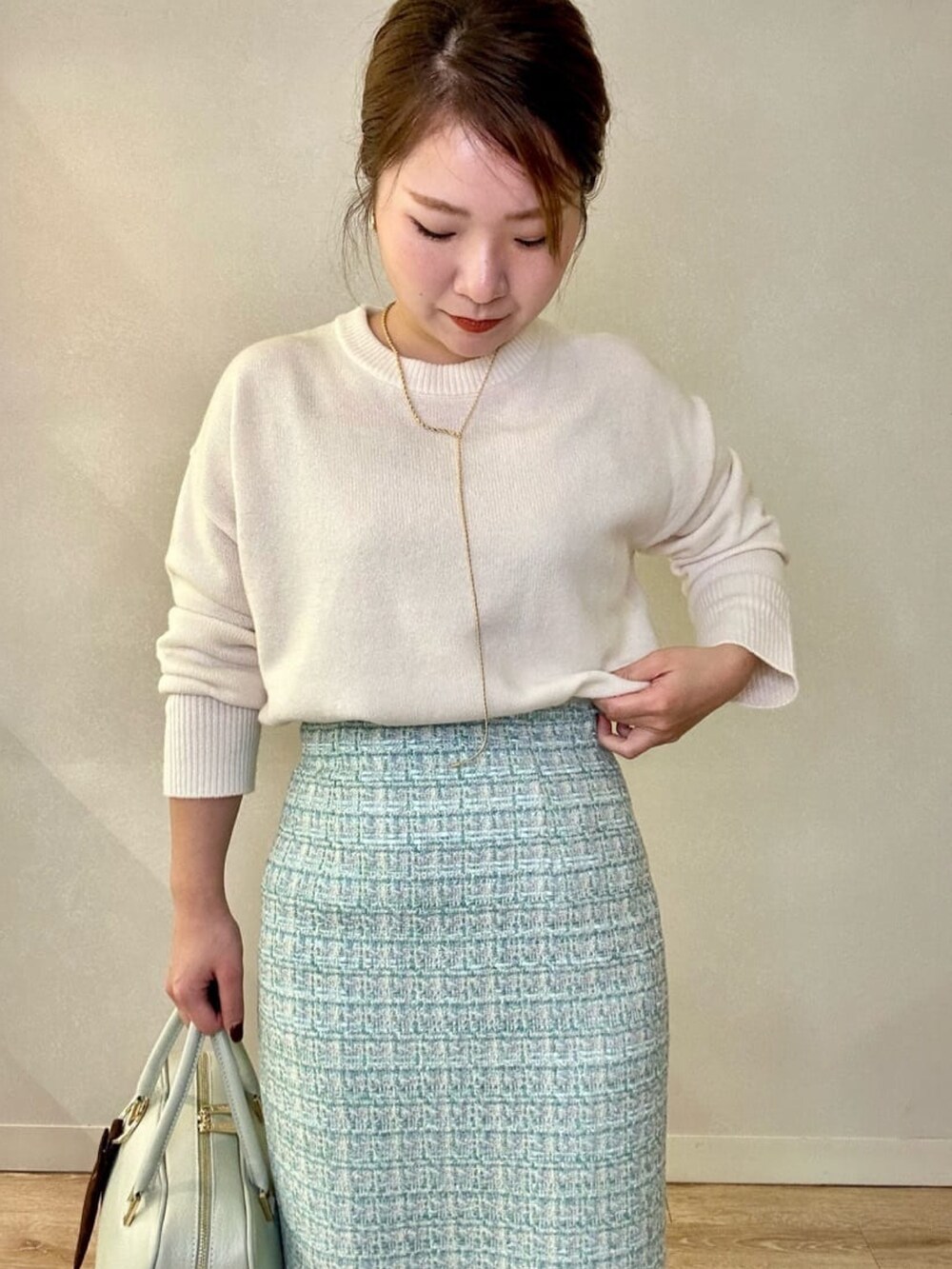 グリーン系のショルダーバッグ、ホワイト系のニット/セーター、イエロー系のその他アウターを着用したレディースの冬コーディネートの3枚目の写真