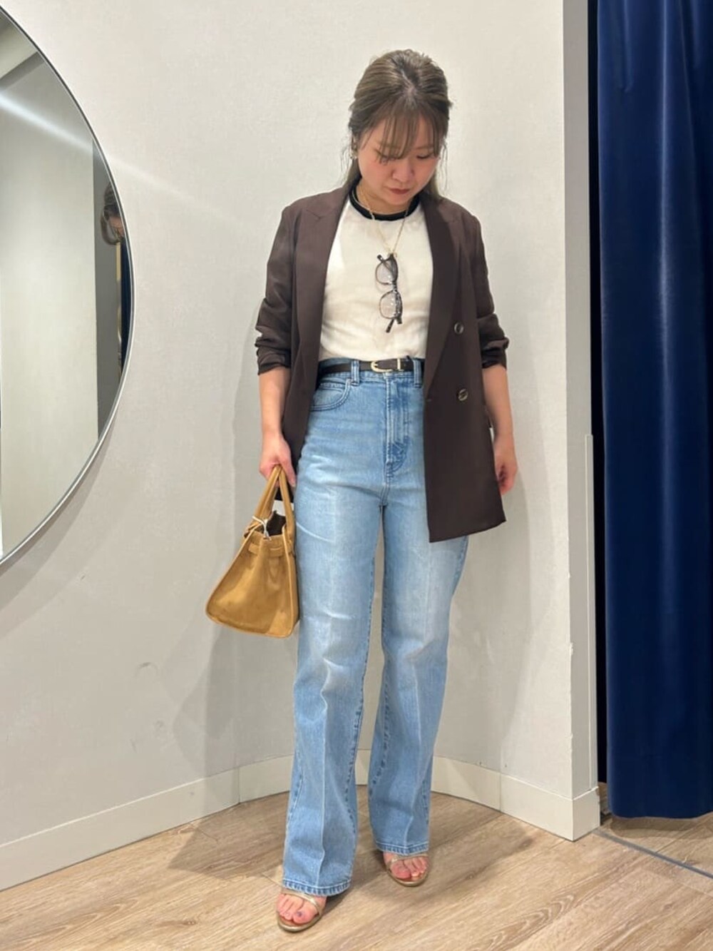 ブルー系のデニムパンツ、イエロー系のトートバッグ、ブラウン系のテーラードジャケットを着用したレディースの夏コーディネートの3枚目の写真