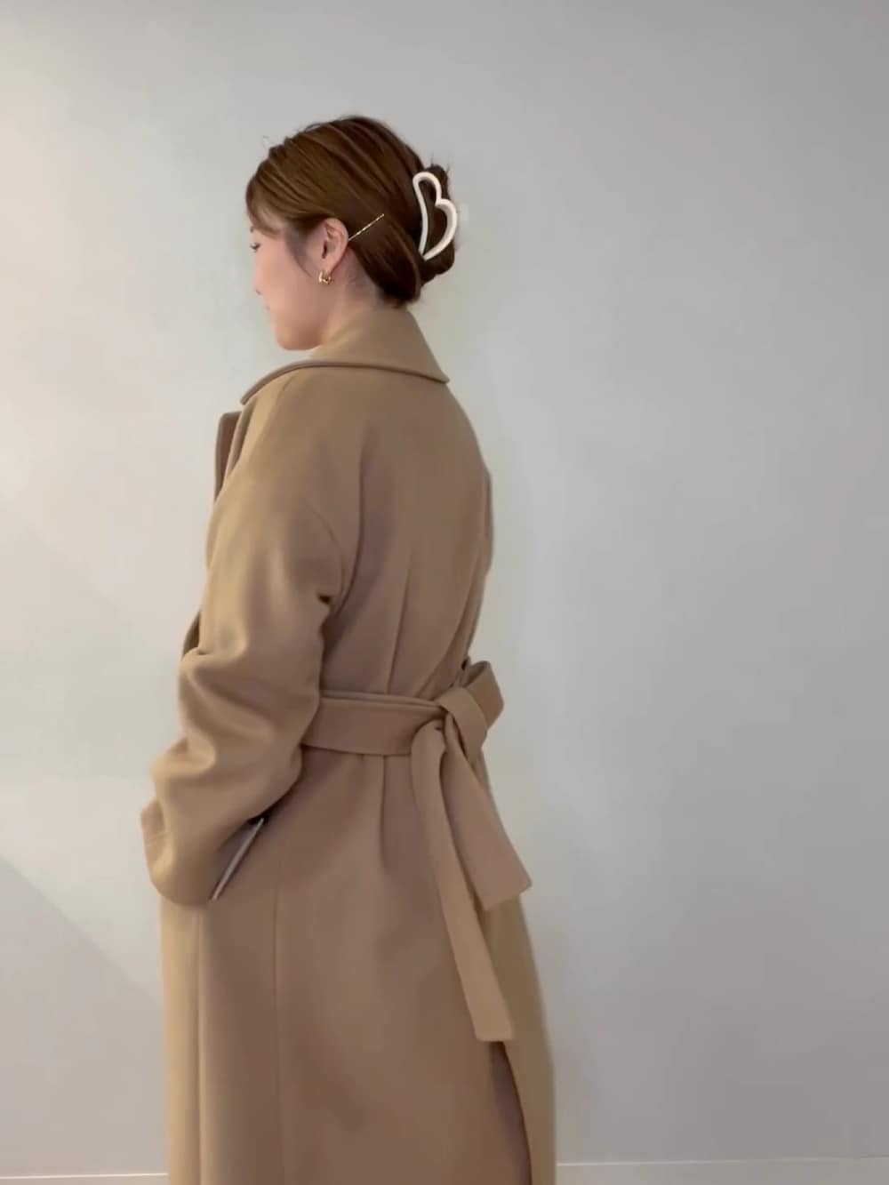 グリーン系のショルダーバッグ、ホワイト系のニット/セーター、イエロー系のその他アウターを着用したレディースの冬コーディネートの6枚目の写真