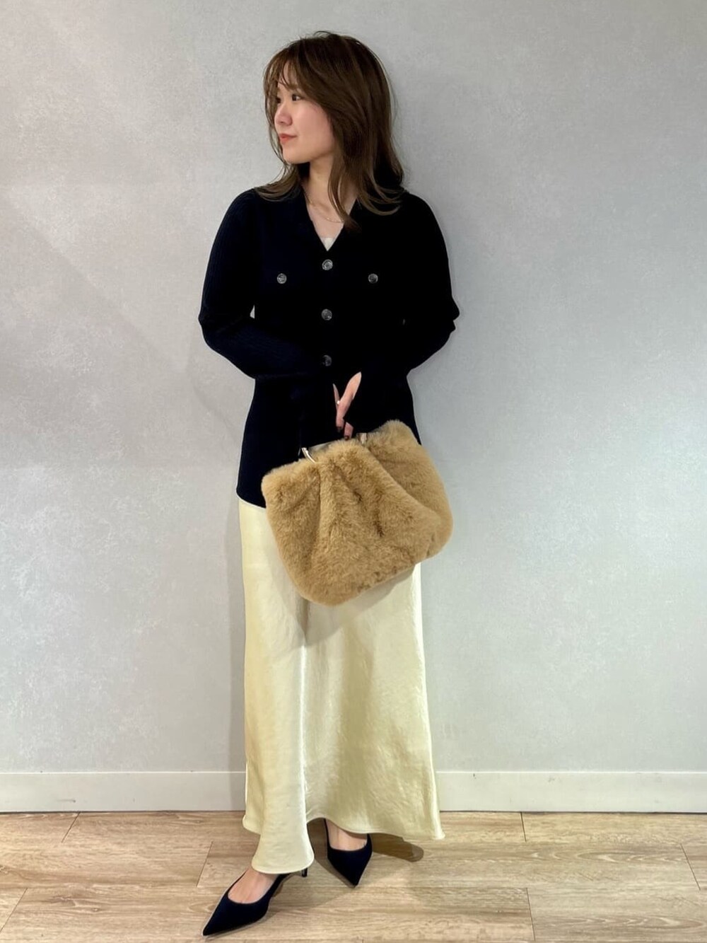 イエロー系のスカート、ベージュ系のショルダーバッグ、ブルー系のカーディガン/ボレロを着用したレディースの冬コーディネートの5枚目の写真