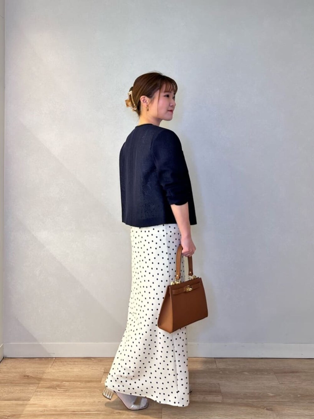 ホワイト系のスカート、イエロー系のショルダーバッグ、ブルー系のノーカラージャケットを着用したレディースの春コーディネートの3枚目の写真