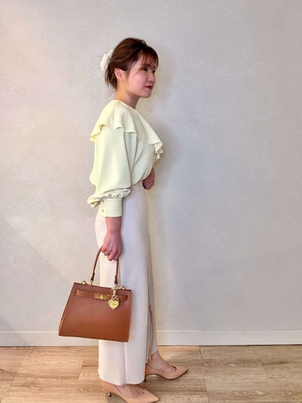 ブラック系のスカート、イエロー系のシャツ/ブラウス、イエロー系のショルダーバッグを着用したレディースの春コーディネートの4枚目の写真
