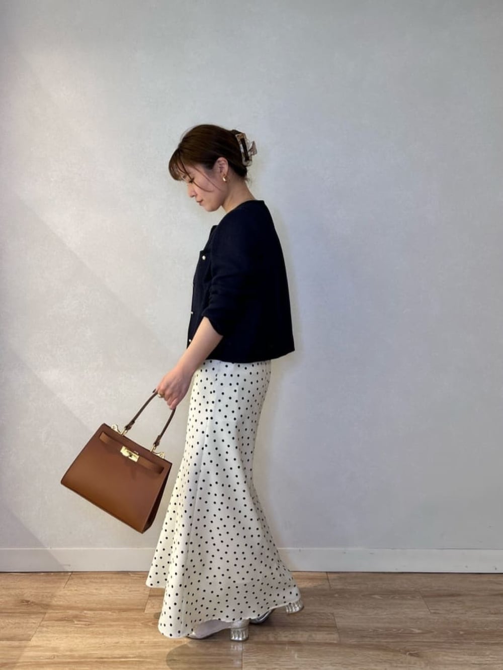 ホワイト系のスカート、イエロー系のショルダーバッグ、ブルー系のノーカラージャケットを着用したレディースの春コーディネートの4枚目の写真