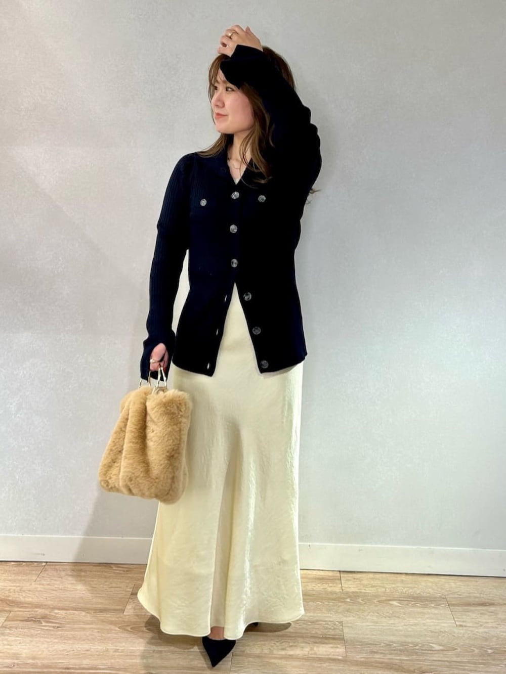 イエロー系のスカート、ベージュ系のショルダーバッグ、ブルー系のカーディガン/ボレロを着用したレディースの冬コーディネートの2枚目の写真
