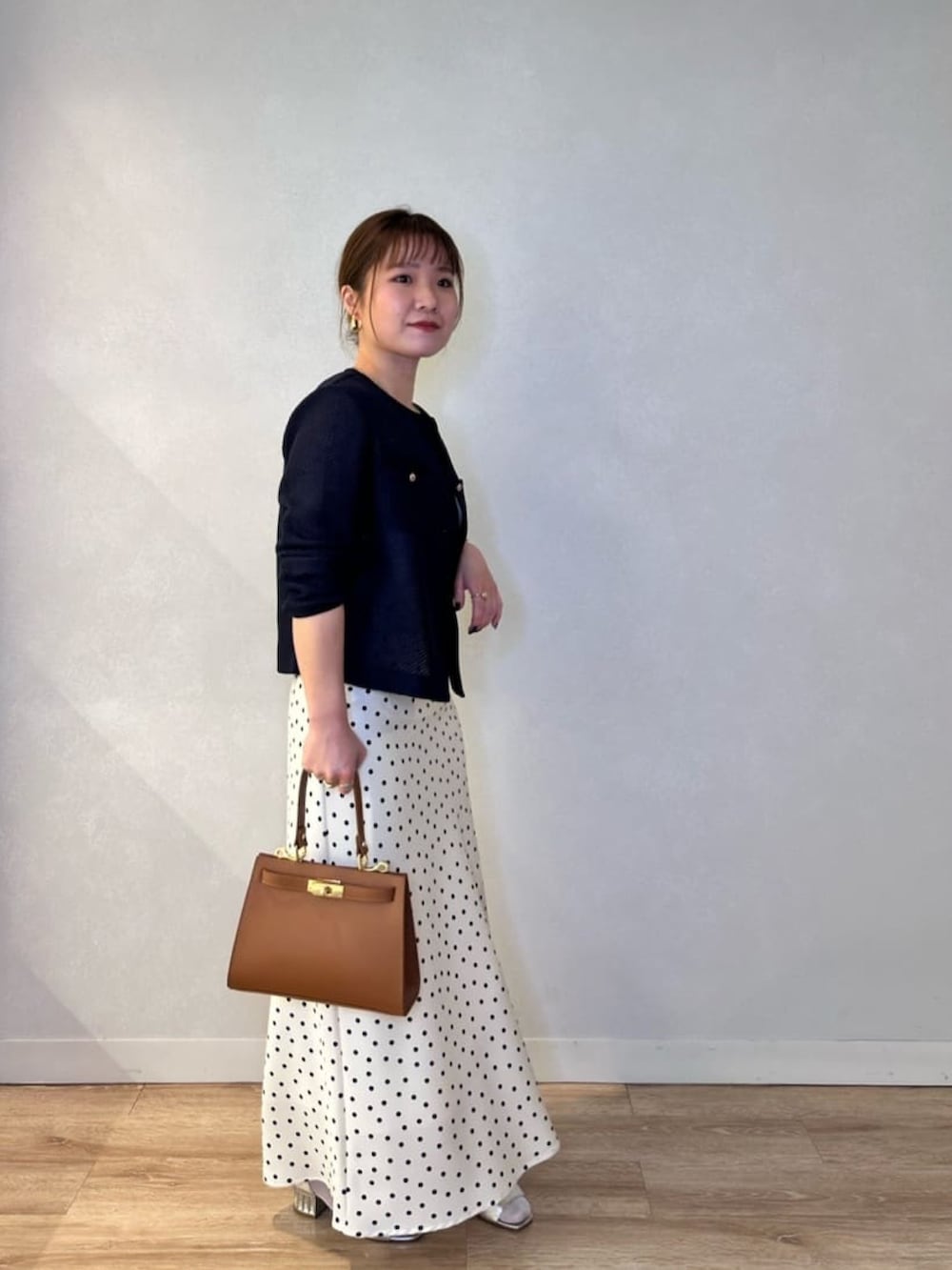 ホワイト系のスカート、イエロー系のショルダーバッグ、ブルー系のノーカラージャケットを着用したレディースの春コーディネートの2枚目の写真