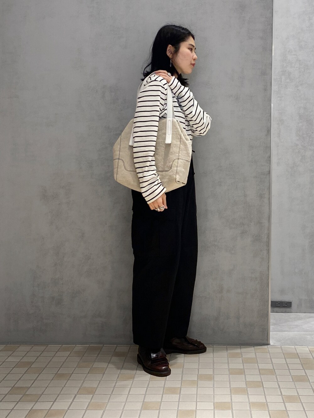 ベージュ系のトートバッグ、シルバー系のリングを着用したレディースの春コーディネートの2枚目の写真