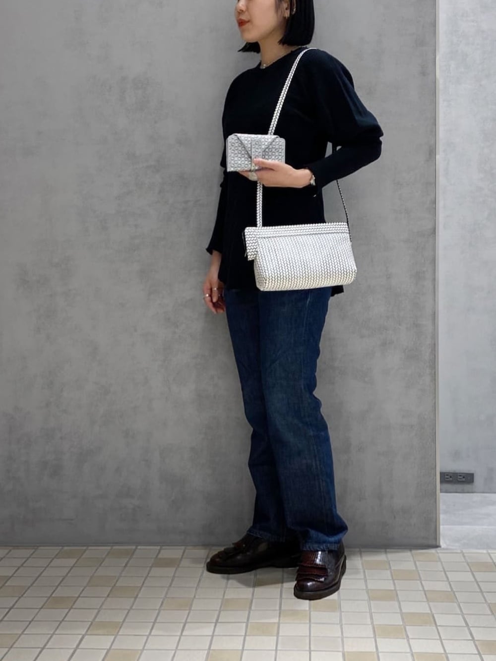 ホワイト系のショルダーバッグ、シルバー系の財布、シルバー系のリングを着用したレディースの冬コーディネートの3枚目の写真