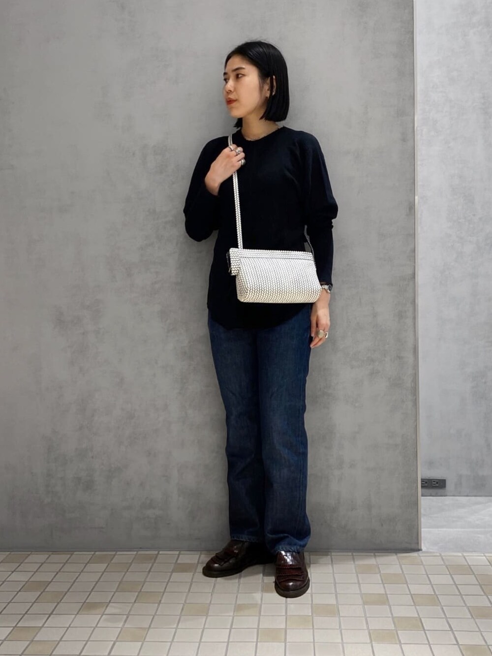 ホワイト系のショルダーバッグ、シルバー系の財布、シルバー系のリングを着用したレディースの冬コーディネートの2枚目の写真