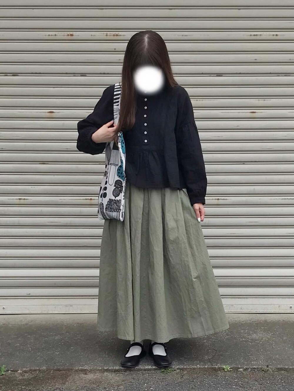 グレー系のトートバッグ、ブラック系のシャツ/ブラウス、グリーン系のスカートを着用したレディースの春コーディネートの3枚目の写真