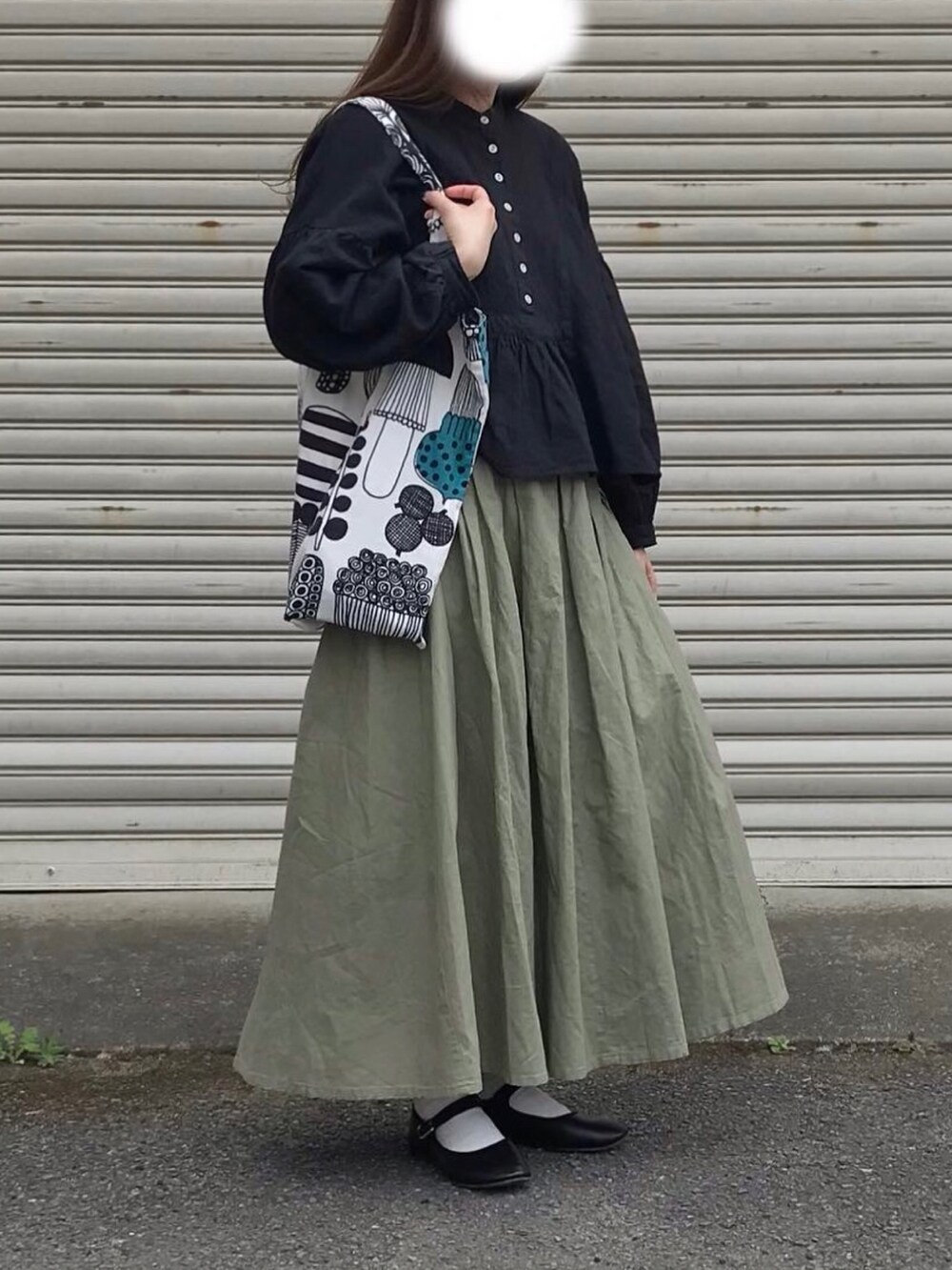 グレー系のトートバッグ、ブラック系のシャツ/ブラウス、グリーン系のスカートを着用したレディースの春コーディネートの2枚目の写真