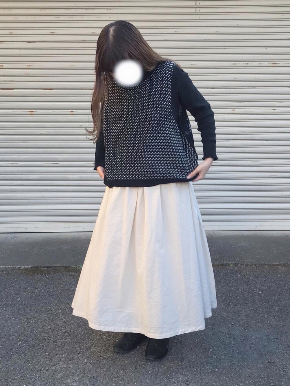 ホワイト系のスカート、ブラック系のローファー、ブラック系のベストを着用したレディースの冬コーディネートの2枚目の写真
