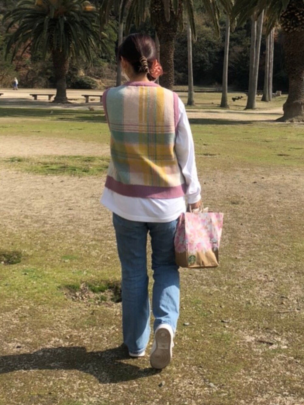 ブルー系のデニムパンツ、ホワイト系のスニーカー、ホワイト系のTシャツ/カットソーを着用したレディースの秋コーディネートの2枚目の写真