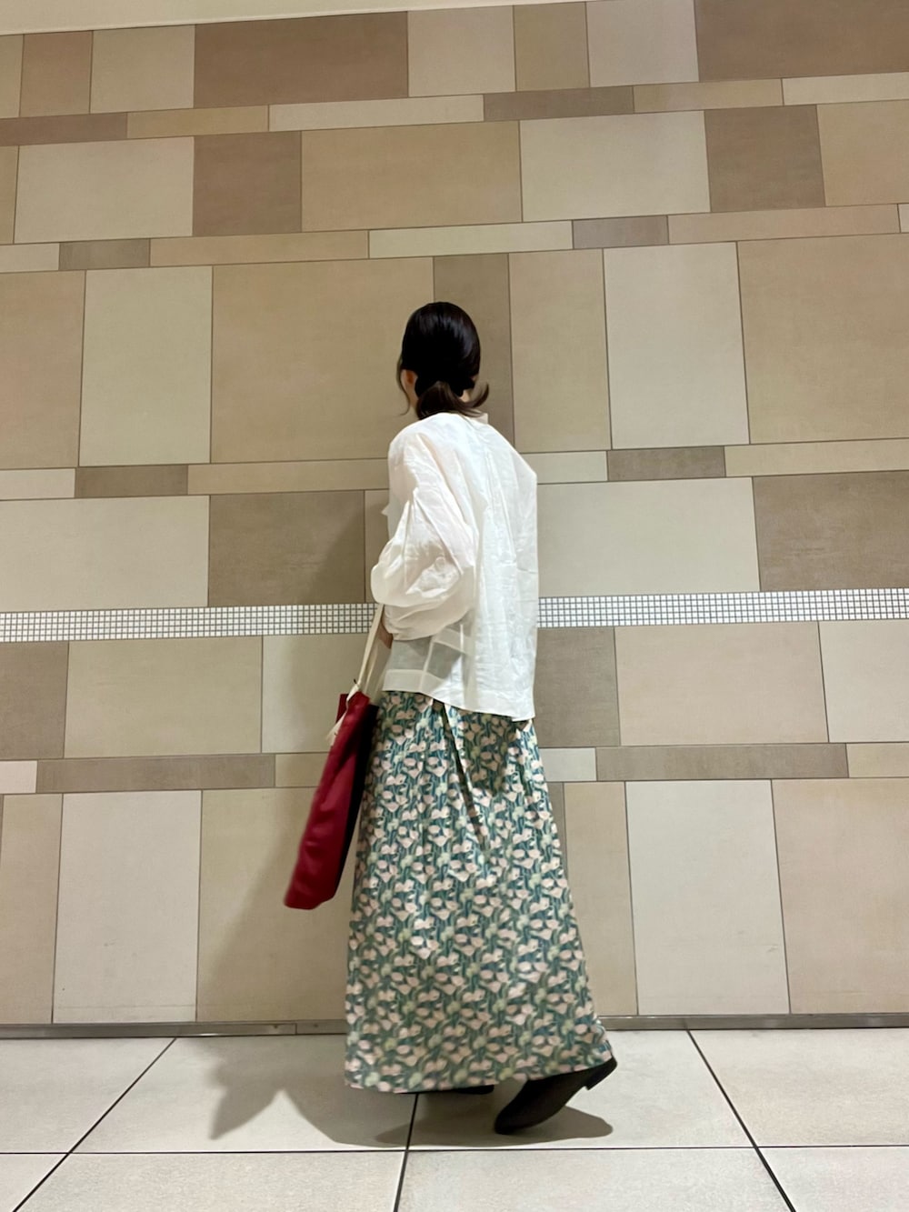 ホワイト系のシャツ/ブラウス、グリーン系のスカート、ブラウン系のローファーを着用したレディースの秋コーディネートの2枚目の写真