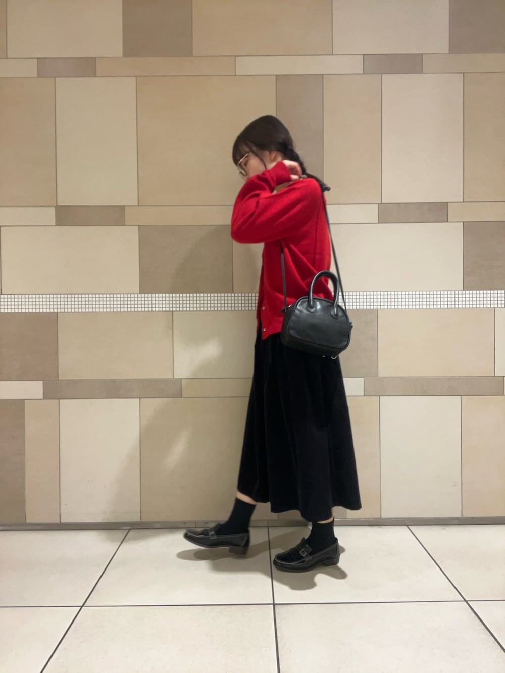 レッド系のカーディガン/ボレロ、グレー系のスカート、ブラック系のローファーを着用したレディースの秋コーディネートの4枚目の写真