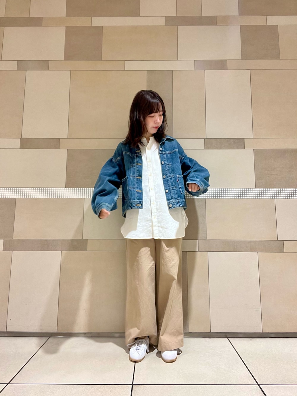 ブルー系のデニムジャケット、ベージュ系のその他パンツ、ホワイト系のシャツ/ブラウスを着用したレディースの秋コーディネートの4枚目の写真