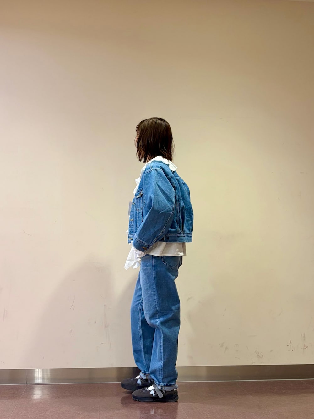 ブルー系のデニムジャケット、ホワイト系のシャツ/ブラウス、ブルー系のデニムパンツを着用したレディースの春コーディネートの2枚目の写真