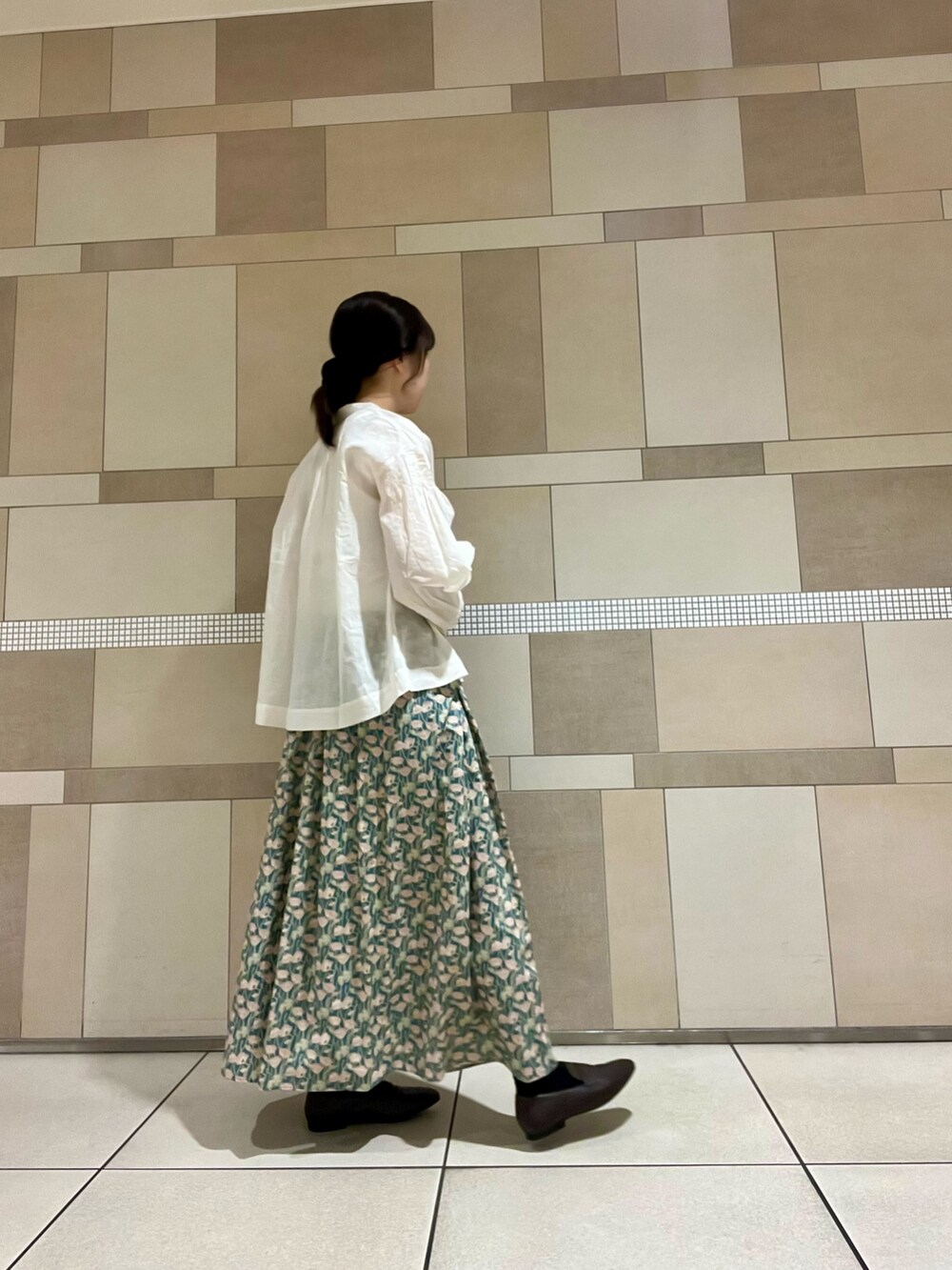 ホワイト系のシャツ/ブラウス、グリーン系のスカート、ブラウン系のローファーを着用したレディースの秋コーディネートの3枚目の写真