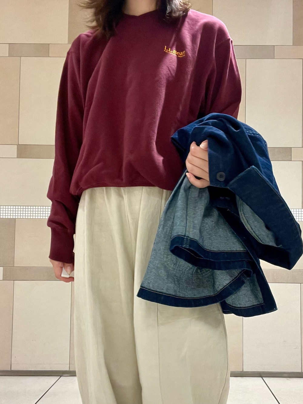 レッド系のスウェット、ブルー系のカバーオール、ベージュ系のサンダルを着用したレディースの秋コーディネートの4枚目の写真