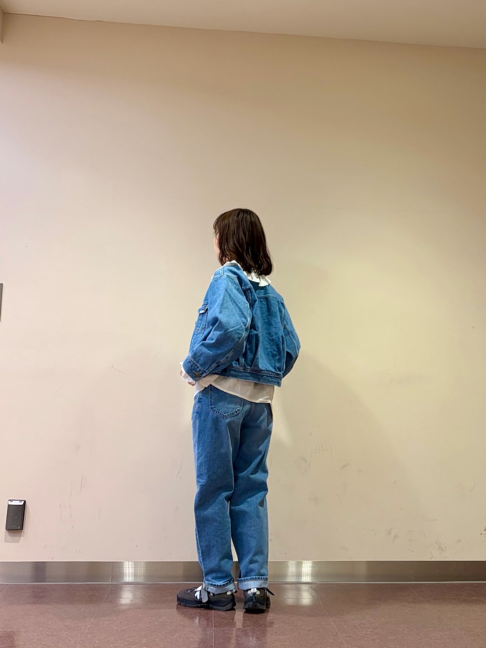 ブルー系のデニムジャケット、ホワイト系のシャツ/ブラウス、ブルー系のデニムパンツを着用したレディースの春コーディネートの3枚目の写真