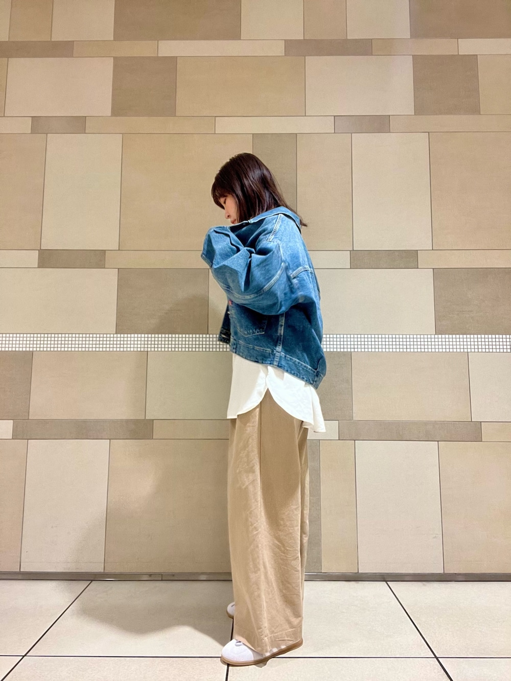 ブルー系のデニムジャケット、ベージュ系のその他パンツ、ホワイト系のシャツ/ブラウスを着用したレディースの秋コーディネートの3枚目の写真