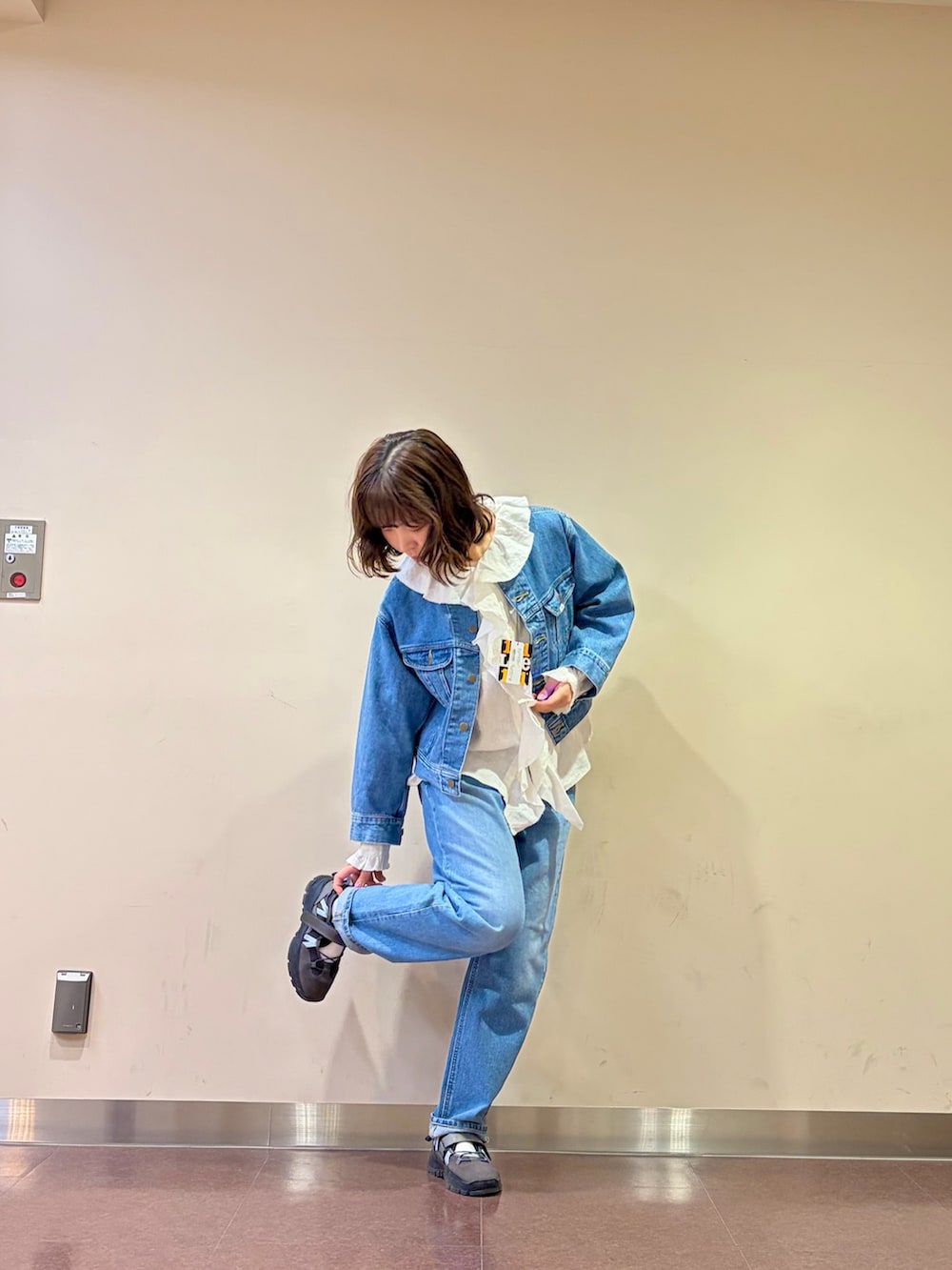 ブルー系のデニムジャケット、ホワイト系のシャツ/ブラウス、ブルー系のデニムパンツを着用したレディースの春コーディネートの5枚目の写真