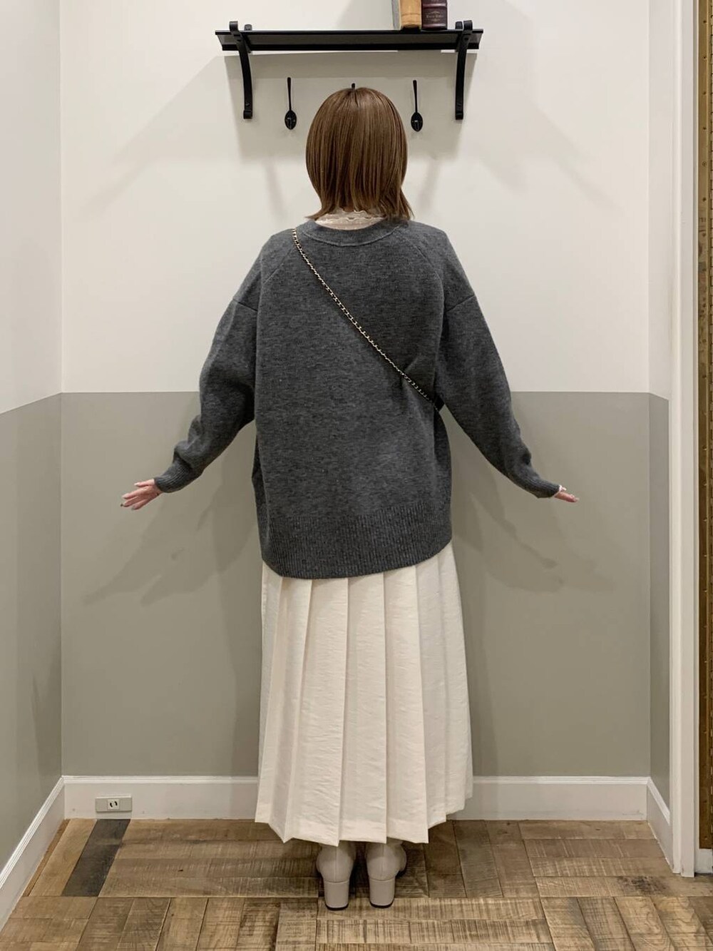 グレー系のカーディガン/ボレロ、ベージュ系のブーツ、ホワイト系のTシャツ/カットソーを着用したレディースの冬コーディネートの4枚目の写真