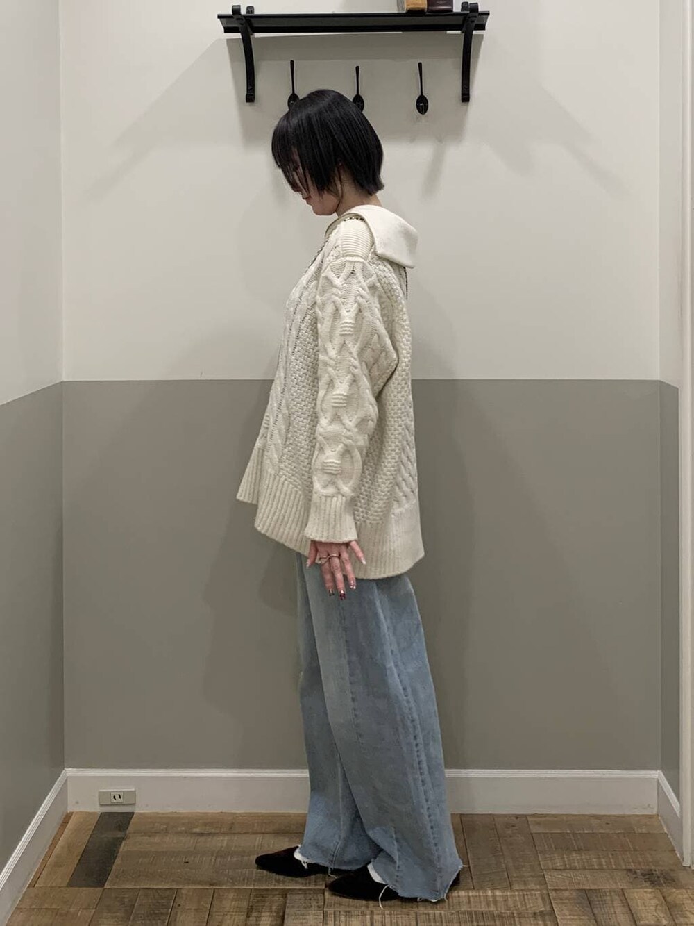 ブルー系のショルダーバッグ、ホワイト系のニット/セーター、ブルー系のデニムパンツを着用したレディースの冬コーディネートの3枚目の写真