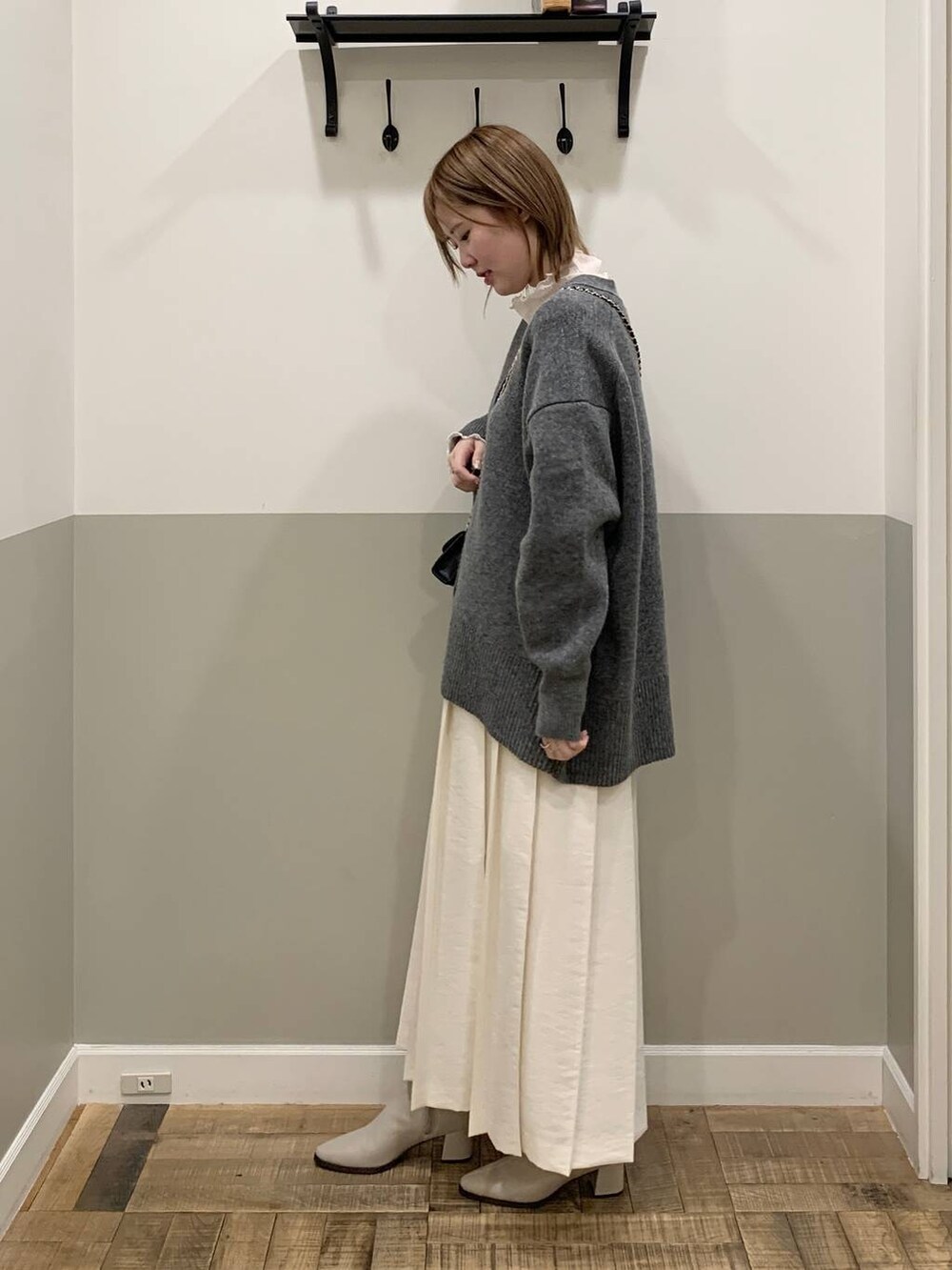 グレー系のカーディガン/ボレロ、ベージュ系のブーツ、ホワイト系のTシャツ/カットソーを着用したレディースの冬コーディネートの3枚目の写真