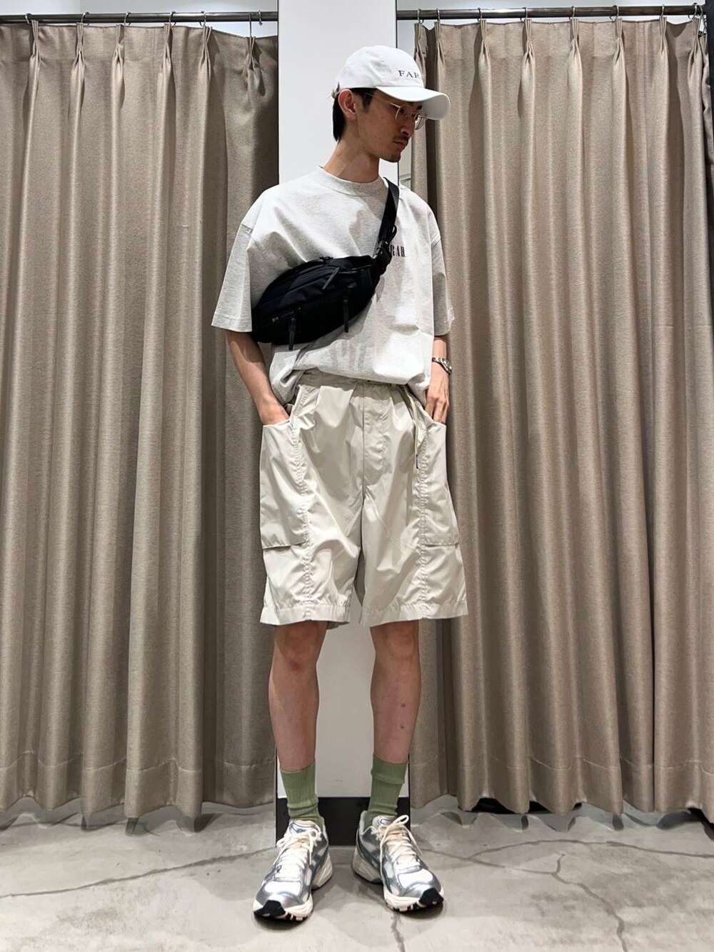 ブラック系のショルダーバッグ、グレー系のTシャツ/カットソー、ホワイト系のスニーカーを着用したメンズの夏コーディネートの2枚目の写真