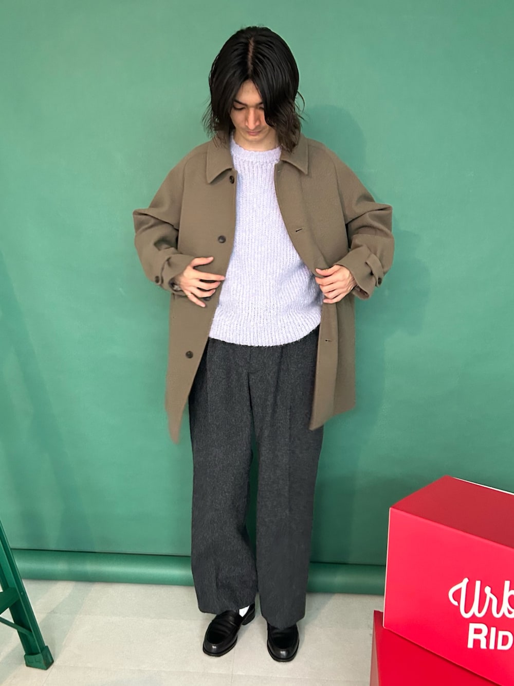 ベージュ系のステンカラーコート、パープル系のニット/セーター、グレー系のその他パンツを着用したメンズの冬コーディネートの2枚目の写真