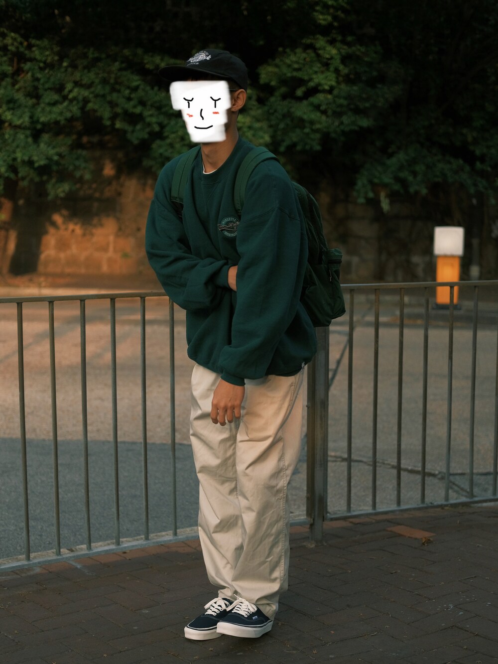 グリーン系のトップス、ベージュ系のチノパンツ、その他のシューズを着用したメンズの春コーディネートの2枚目の写真