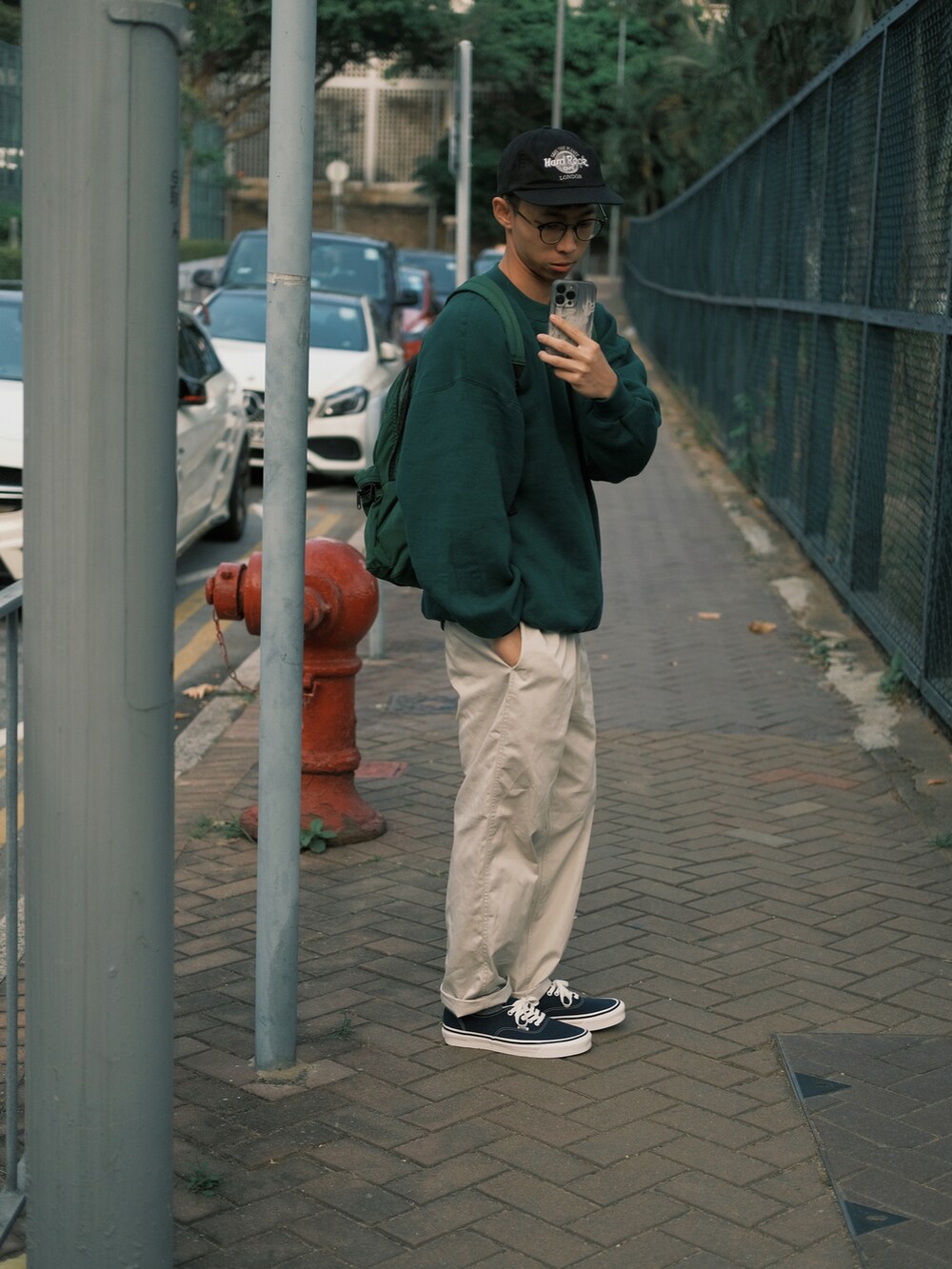 グリーン系のトップス、ベージュ系のチノパンツ、その他のシューズを着用したメンズの春コーディネートの3枚目の写真