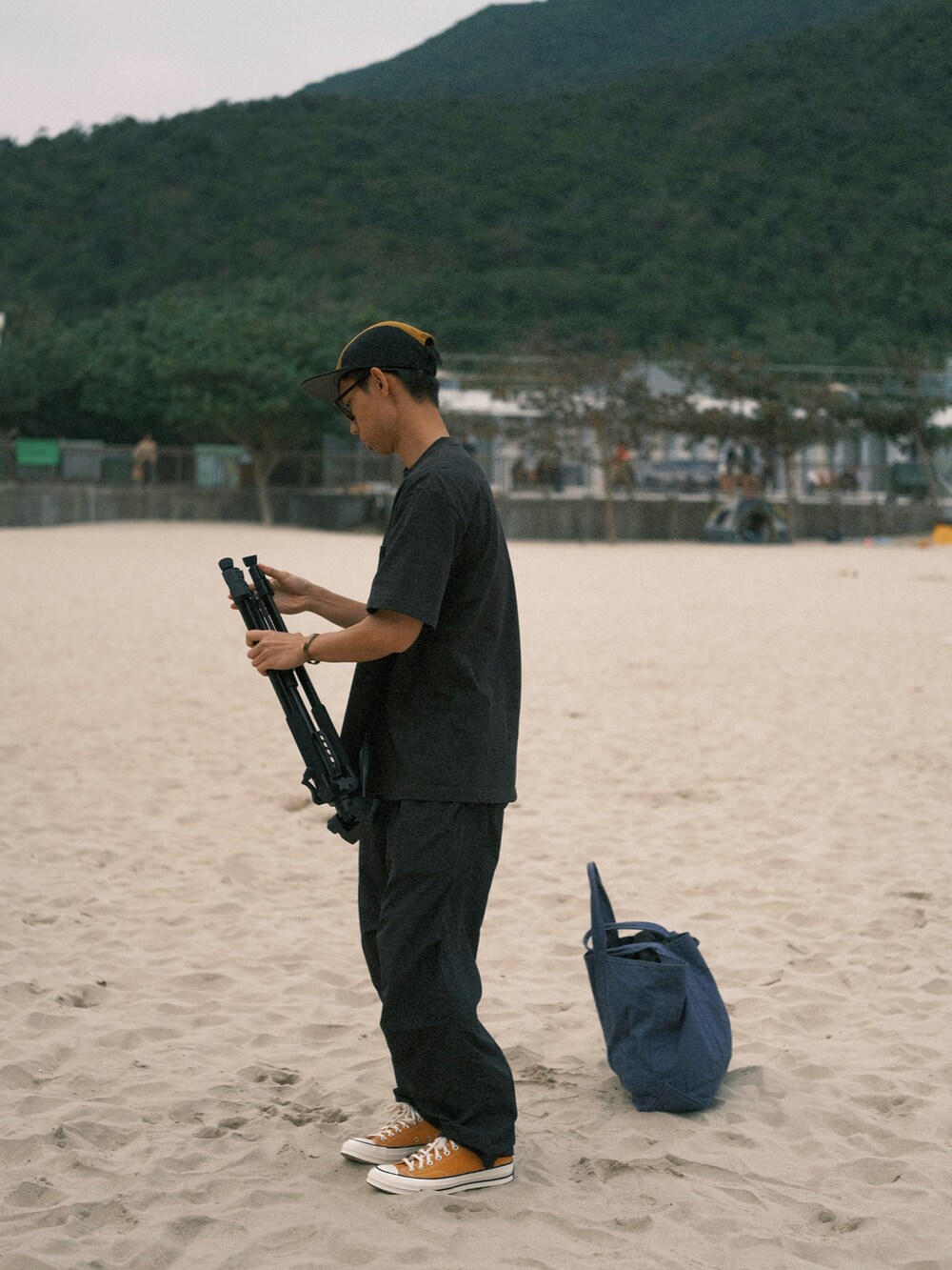 イエロー系のシューズ、オレンジ系の帽子を着用したメンズの春コーディネートの2枚目の写真