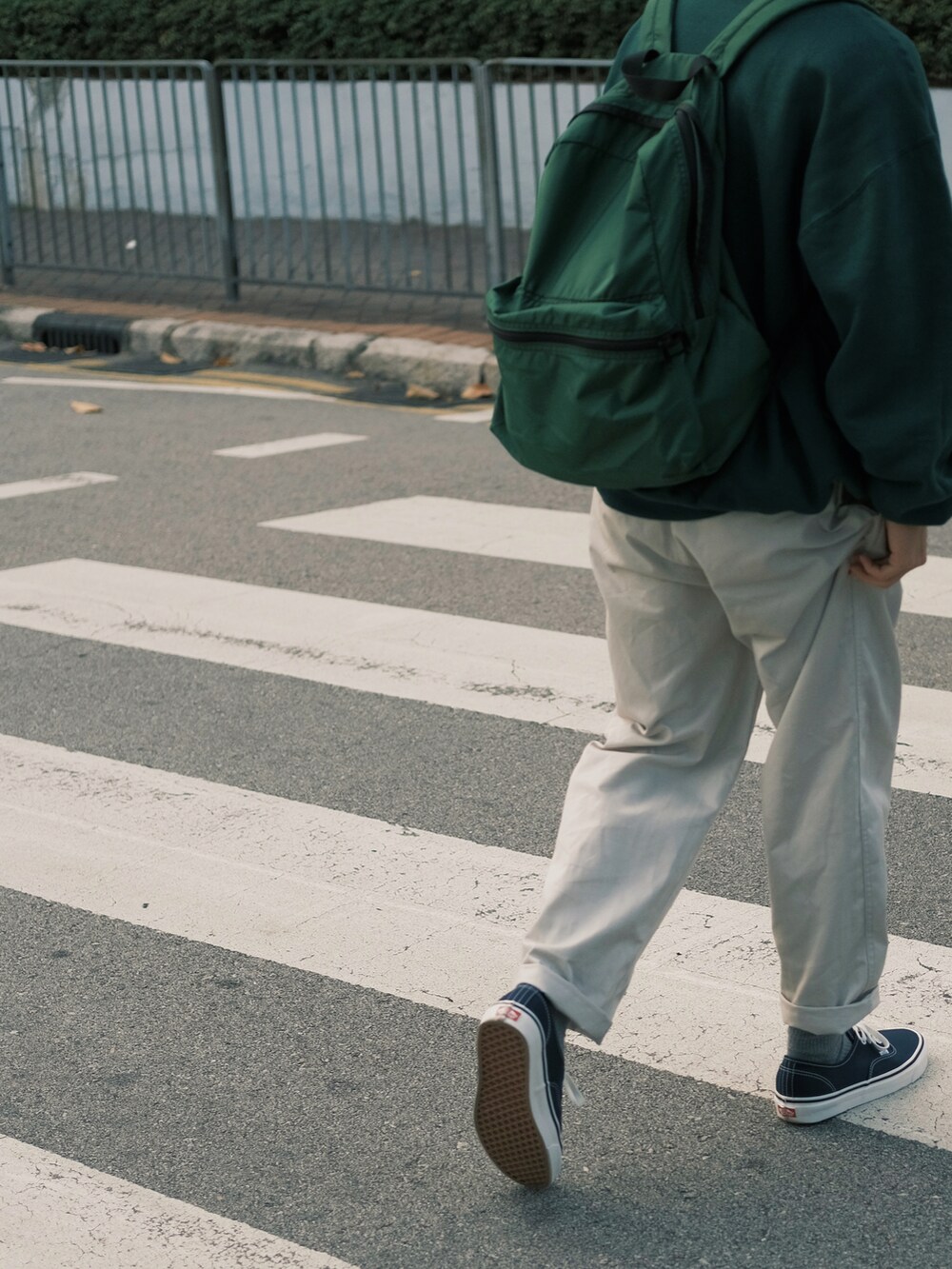 グリーン系のトップス、ベージュ系のチノパンツ、その他のシューズを着用したメンズの春コーディネートの4枚目の写真