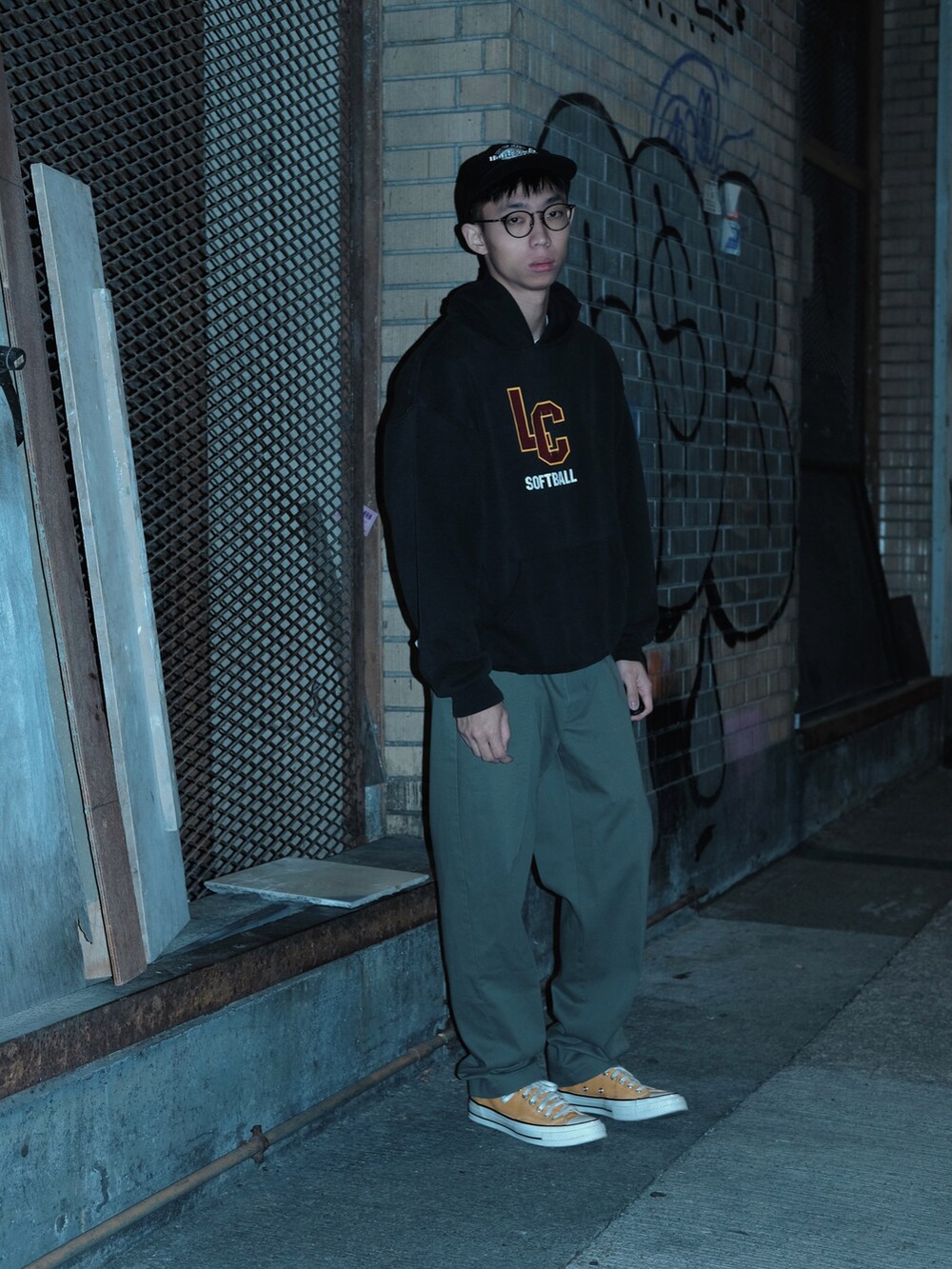 ブラック系のトップス、その他のスラックス、グリーン系の帽子を着用したメンズの春コーディネートの2枚目の写真