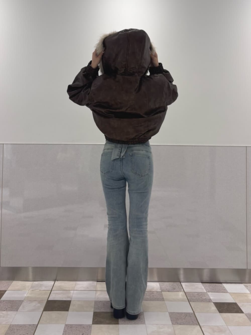ブルー系のデニムパンツ、ブラウン系のブルゾン、ホワイト系のTシャツ/カットソーを着用したレディースの秋コーディネートの3枚目の写真
