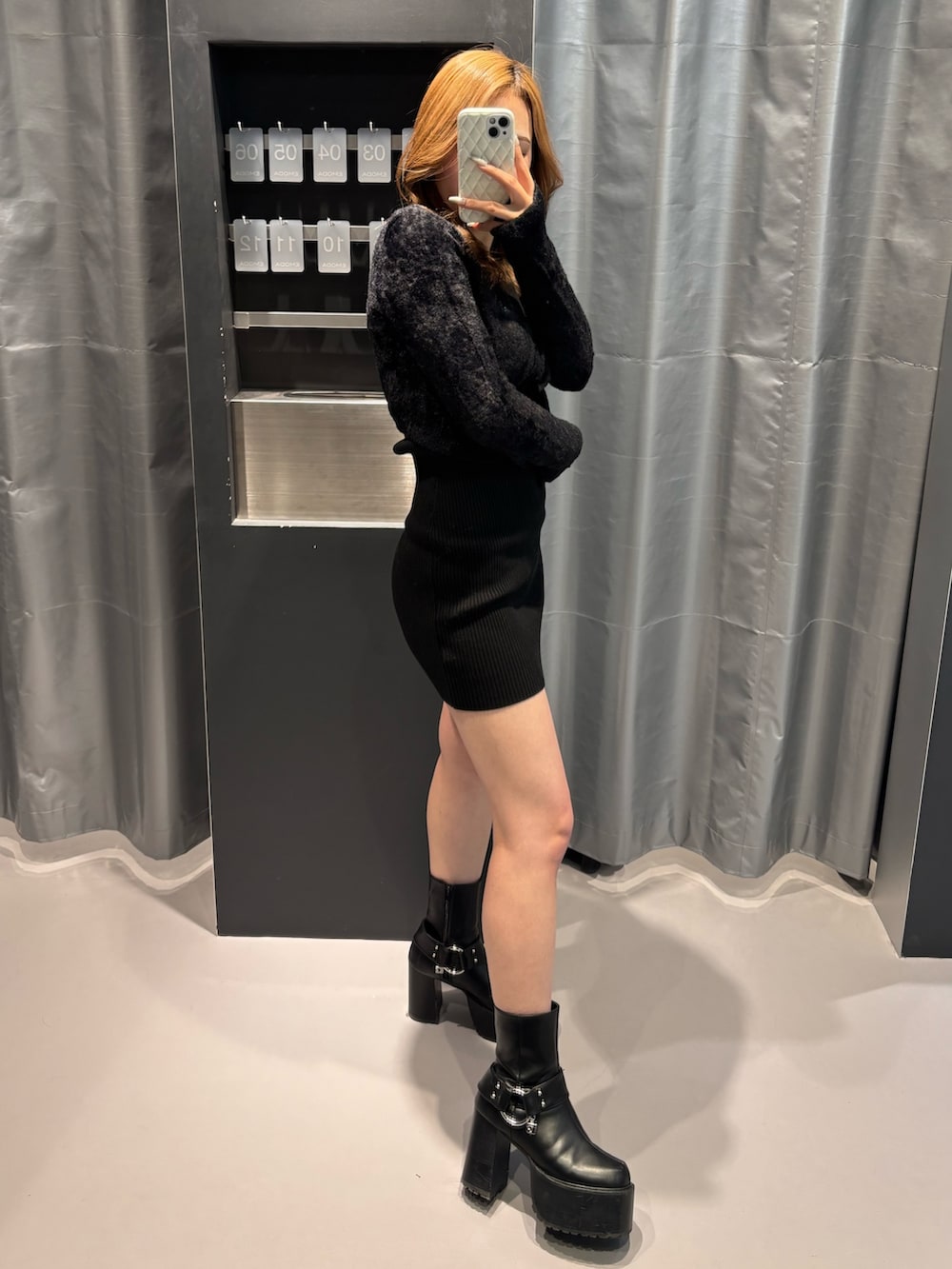 ブラック系のワンピース、ブラック系のブーツを着用したレディースの冬コーディネートの2枚目の写真