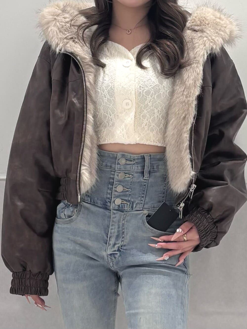 ブルー系のデニムパンツ、ブラウン系のブルゾン、ホワイト系のTシャツ/カットソーを着用したレディースの秋コーディネートの4枚目の写真