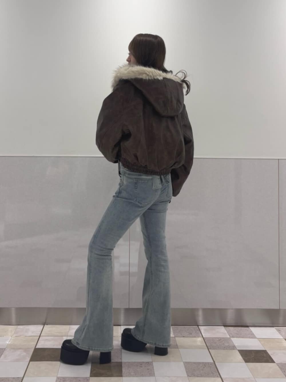ブルー系のデニムパンツ、ブラウン系のブルゾン、ホワイト系のTシャツ/カットソーを着用したレディースの秋コーディネートの2枚目の写真