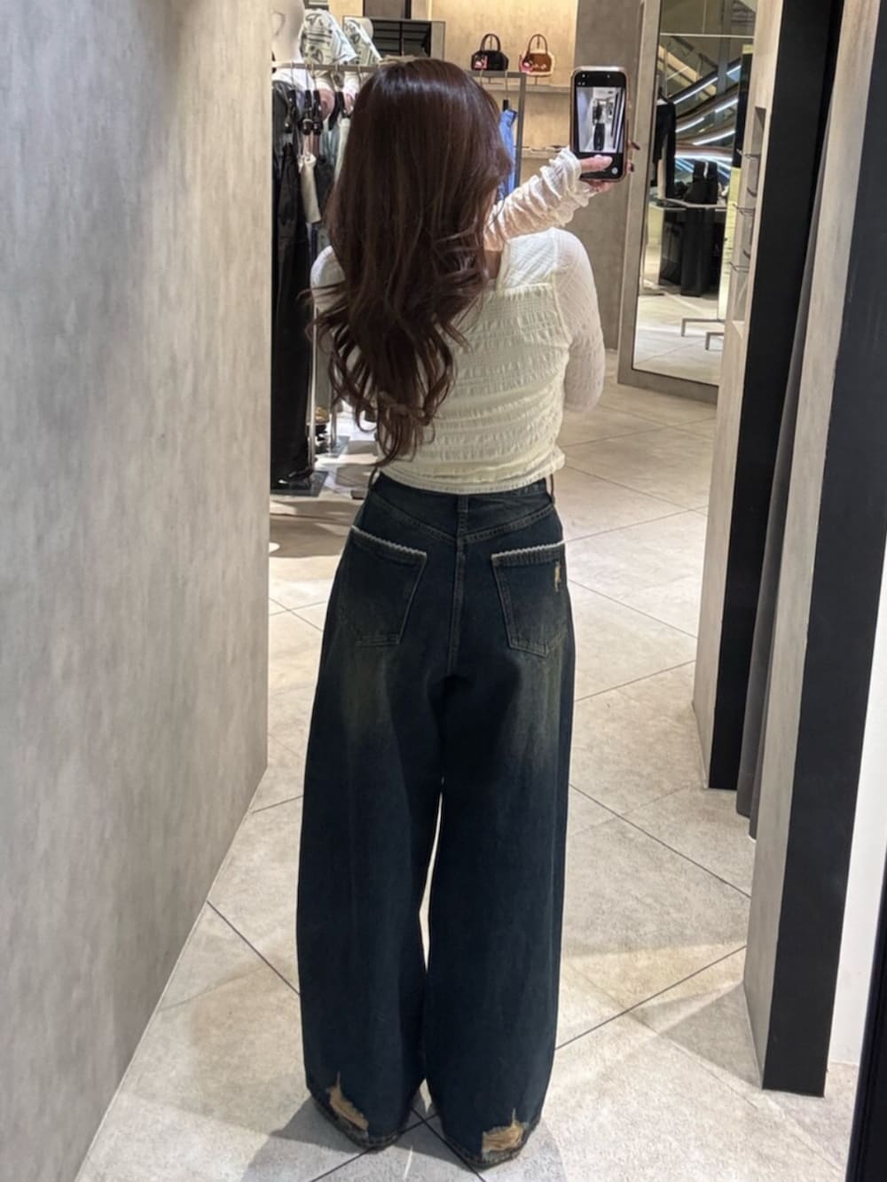 ホワイト系のスニーカー、ホワイト系のTシャツ/カットソー、ブルー系のデニムパンツを着用したレディースの春コーディネートの3枚目の写真