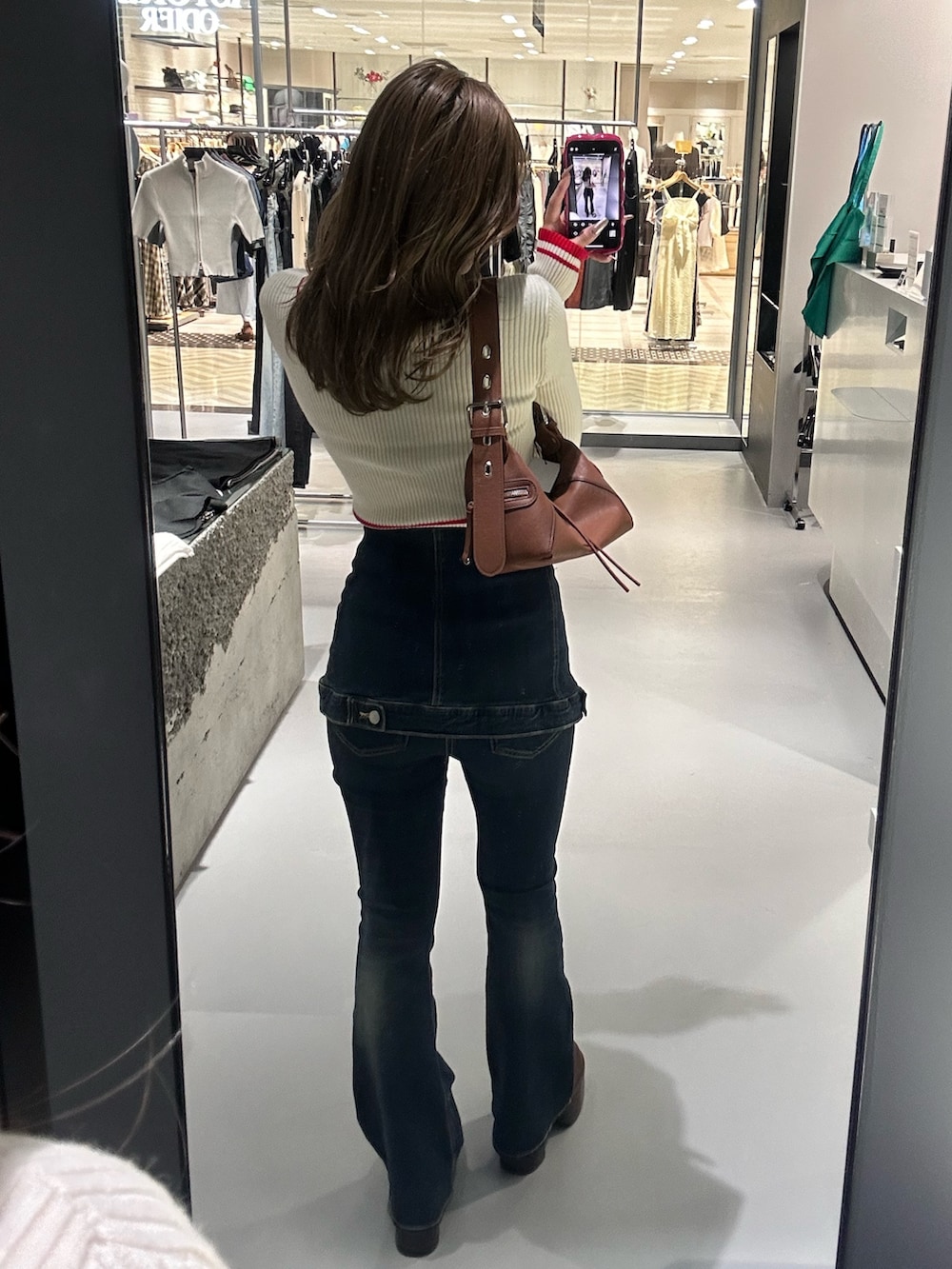 ホワイト系のニット/セーター、ブルー系のデニムパンツ、ブラウン系のブーツを着用したレディースの秋コーディネートの3枚目の写真