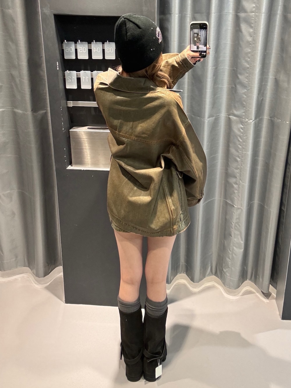 グレー系のニット/セーター、ブラウン系のブルゾン、ブラウン系のスカートを着用したレディースの冬コーディネートの3枚目の写真