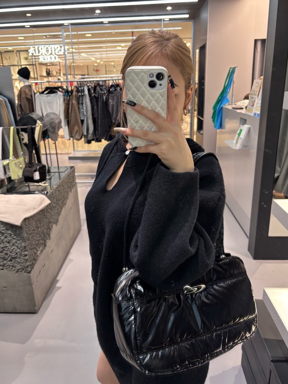 ブラック系のニット/セーター、ブラック系のボストンバッグ、ブラック系のブーツを着用したレディースの冬コーディネートの4枚目の写真