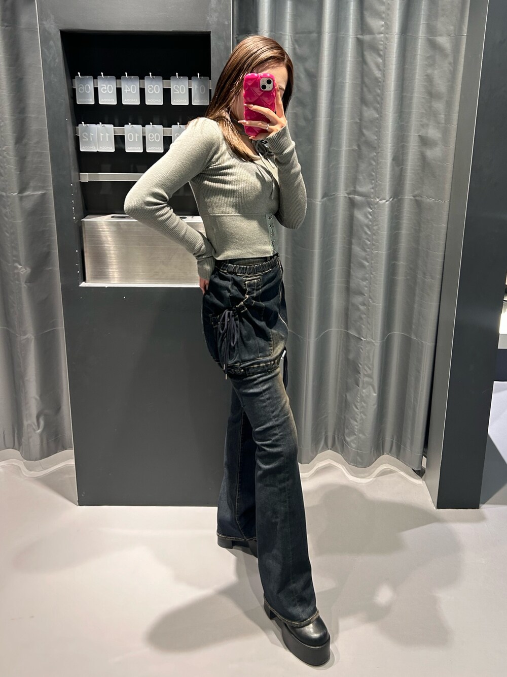 グレー系のニット/セーター、ブルー系のデニムパンツ、ブラック系のブーツを着用したレディースの秋コーディネートの2枚目の写真