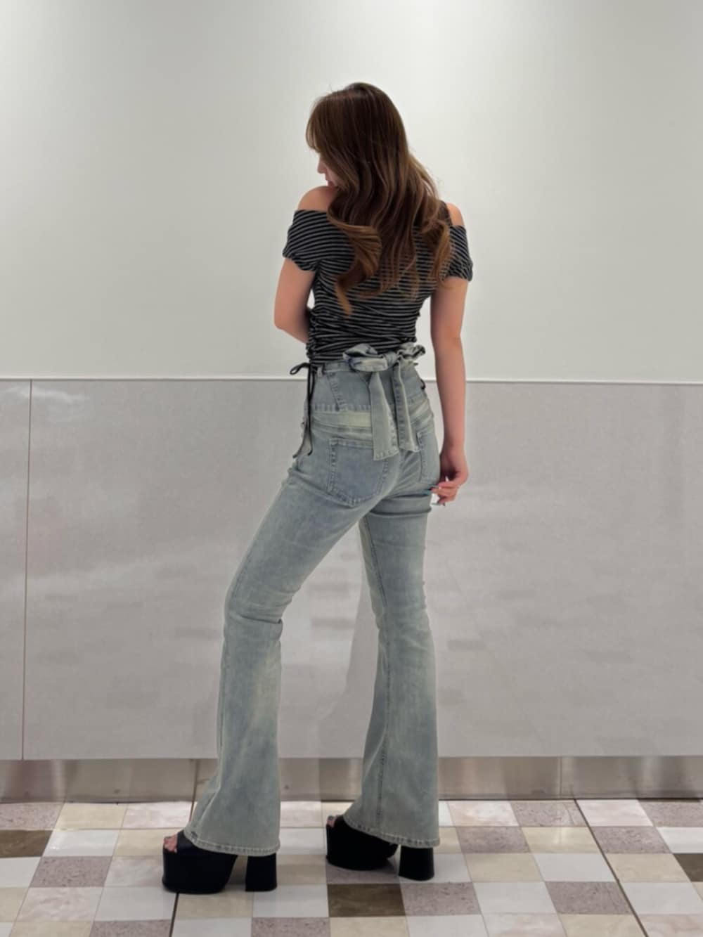 ブラック系のサンダル、ブラック系のTシャツ/カットソー、ブルー系のデニムパンツを着用したレディースの夏コーディネートの2枚目の写真