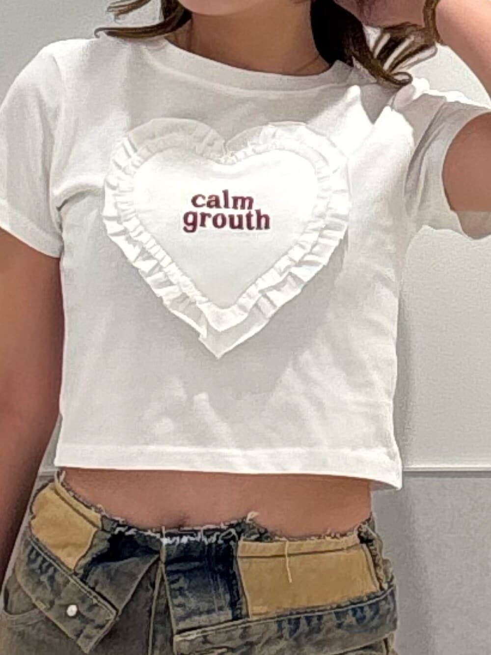 ブラック系のサンダル、ホワイト系のTシャツ/カットソー、ブラウン系のデニムパンツを着用したレディースの夏コーディネートの4枚目の写真