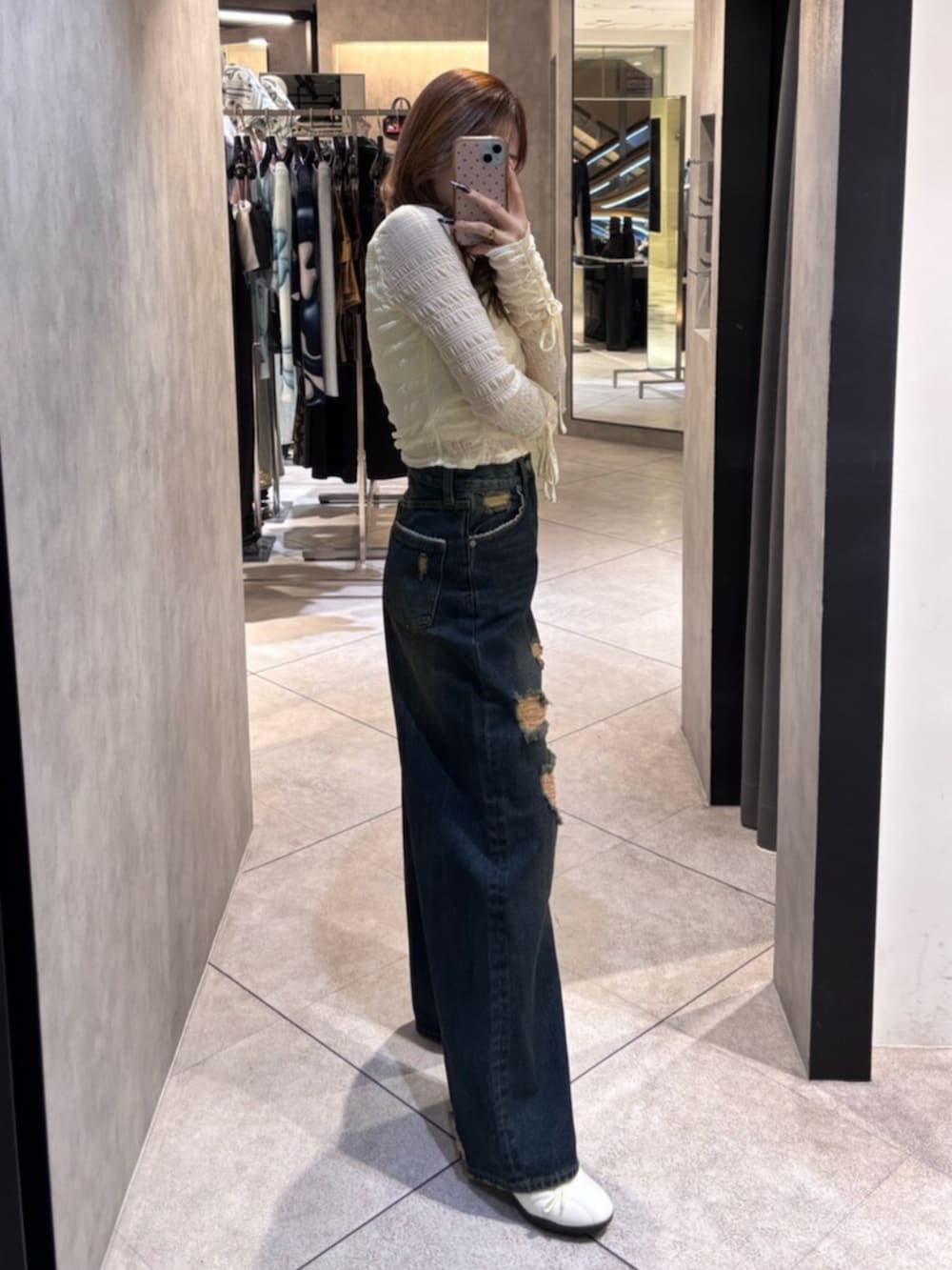 ホワイト系のスニーカー、ホワイト系のTシャツ/カットソー、ブルー系のデニムパンツを着用したレディースの春コーディネートの2枚目の写真