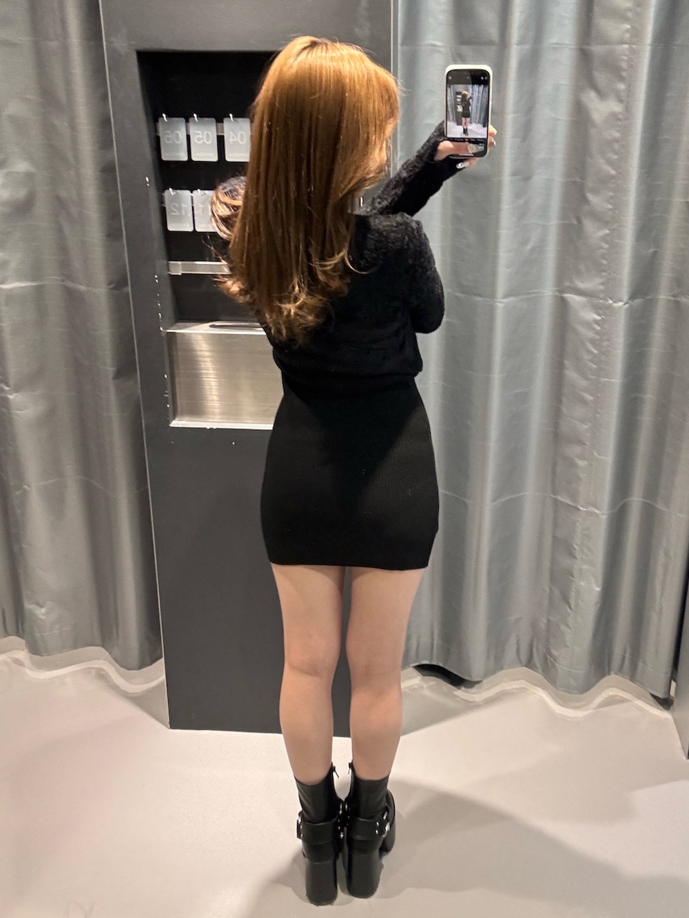 ブラック系のワンピース、ブラック系のブーツを着用したレディースの冬コーディネートの3枚目の写真